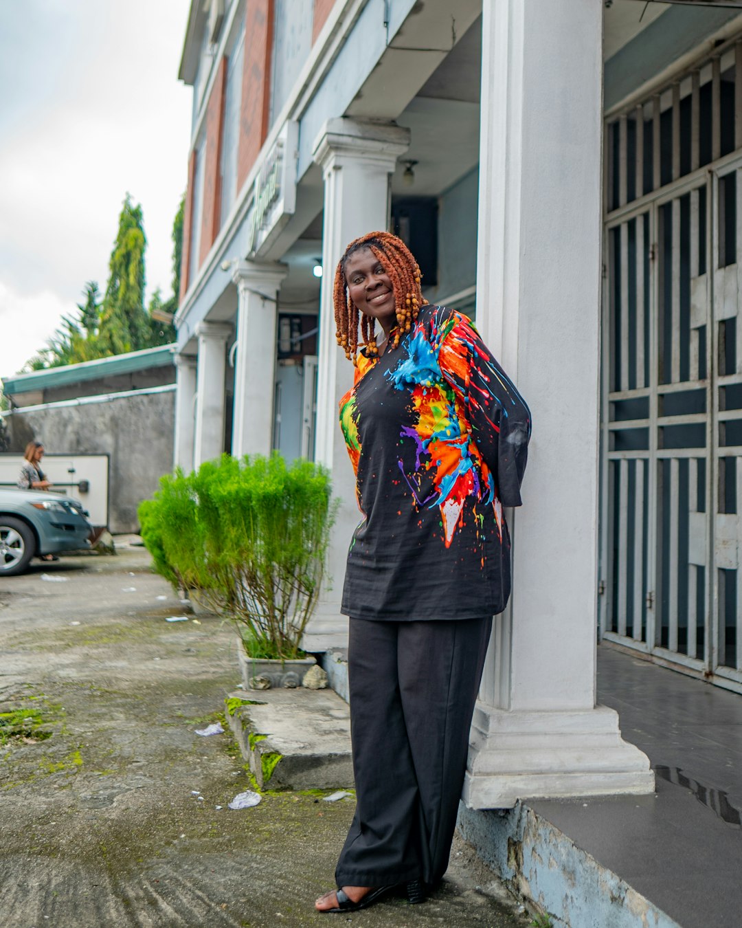 woman-in-colorful-shirt-leans-against-column-5asysf3btoc